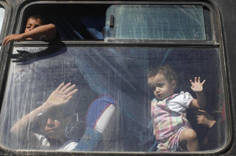 Palestinian children look out of a bus window, in hopes of crossing into Egypt, at the Rafah crossing between Egypt and the southern Gaza Strip. Ibraheem Abu Mustafa/Reuters
