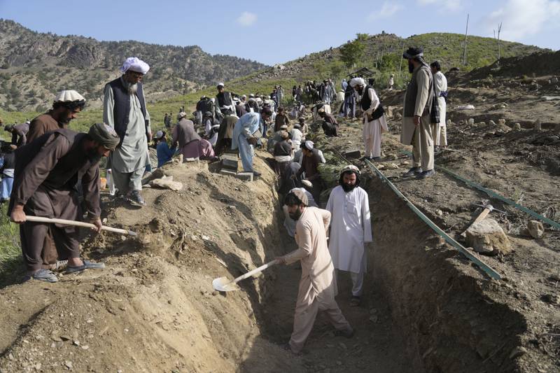 Afghans dig a common grave for their relatives killed by the earthquake in Gayan village. AP