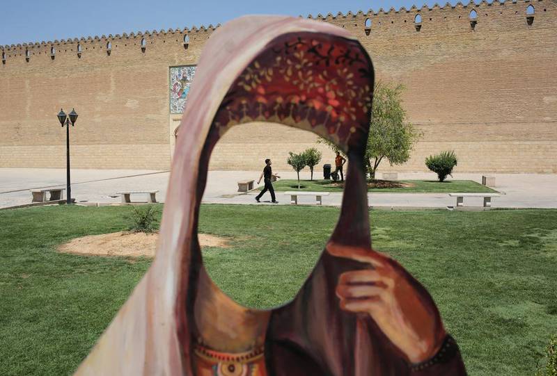 A cutout of a woman in Iranian dress stands in front of the Karim Khani Palace, also a former prison, in Shiraz.