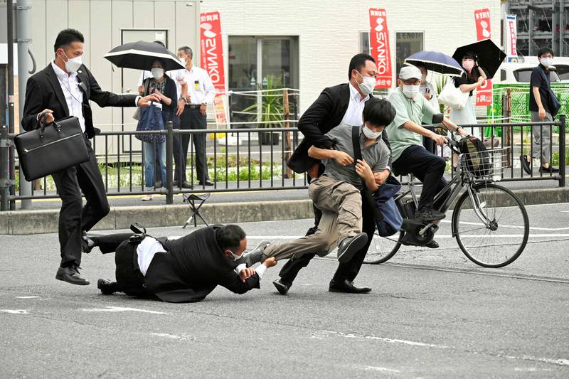 A man suspected of shooting former Japanese prime minister Shinzo Abe is tackled to the ground by police at Yamato Saidaiji Station in the city of Nara. Abe was pronounced dead on July 8. AFP