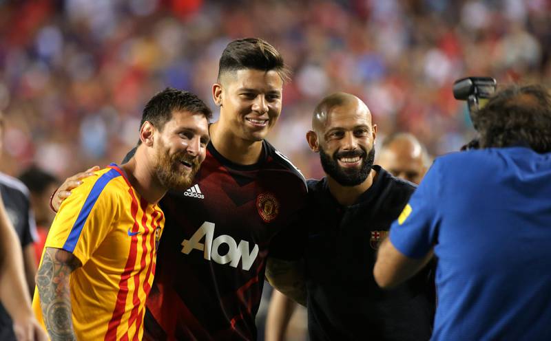 Manchester United's Marcos Rojo, Barcelona's Lionel Messi and Javier Mascherano pose for a photo after the game. Carlos Barria / Reuters