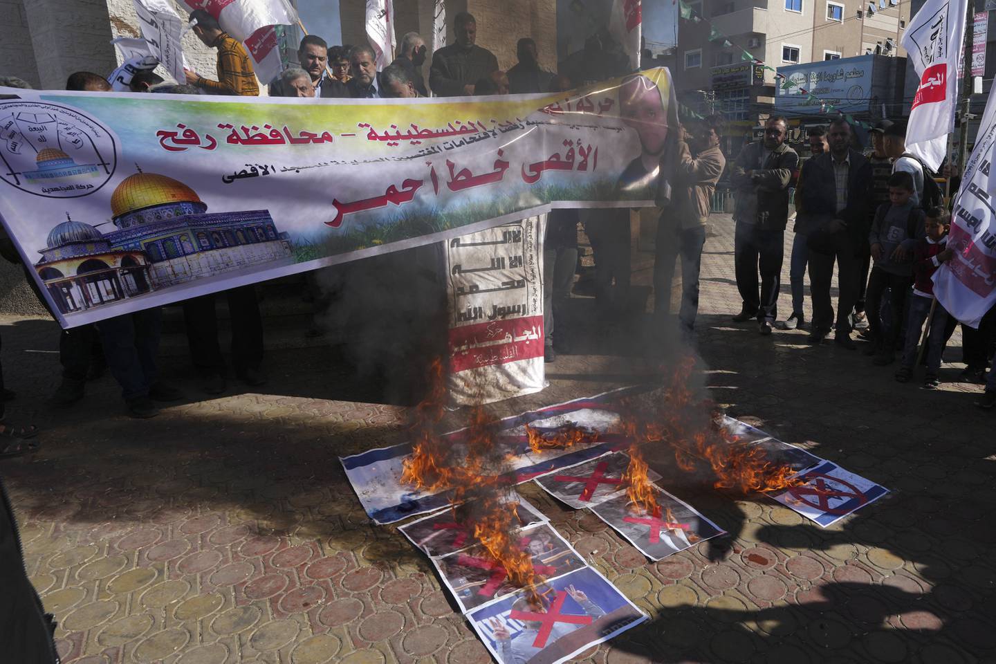 Palestinians burn pictures of Israeli prime minister-designate Benjamin Netanyahu and Israeli politicians Bezalel Smotrich and Itamar Ben-Gvir during a protest in Gaza's Rafah refugee camp. AP