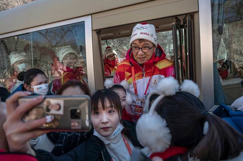 Actor Jackie Chan with student performers after participating in a leg of the Beijing 2022 Winter Olympics torch relay at the Badaling section of the Great Wall of China on February 3. Getty Images