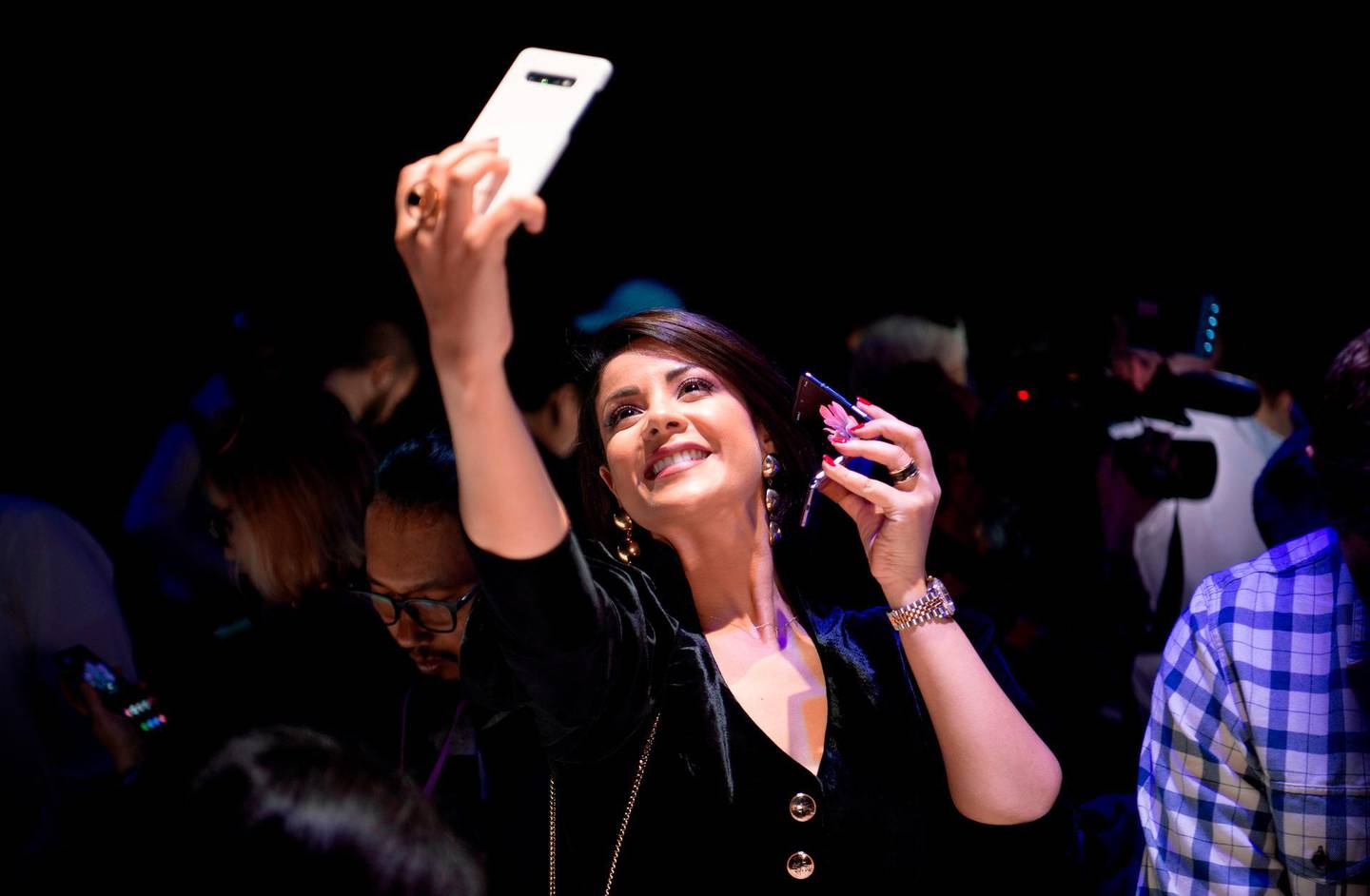 A member of the media takes a selfie while holding s Samsung Galaxy Z Flip phone displayed during the Samsung Galaxy Unpacked 2020 event in San Francisco, California on February 11, 2020.  Samsung unveiled its second folding smartphone, a "Z Flip" handset with a lofty price tag aimed at "trendsetters." The smartphone flips open, like a pocket cosmetics case, opening into a 6.7-inch screen. / AFP / Josh Edelson
