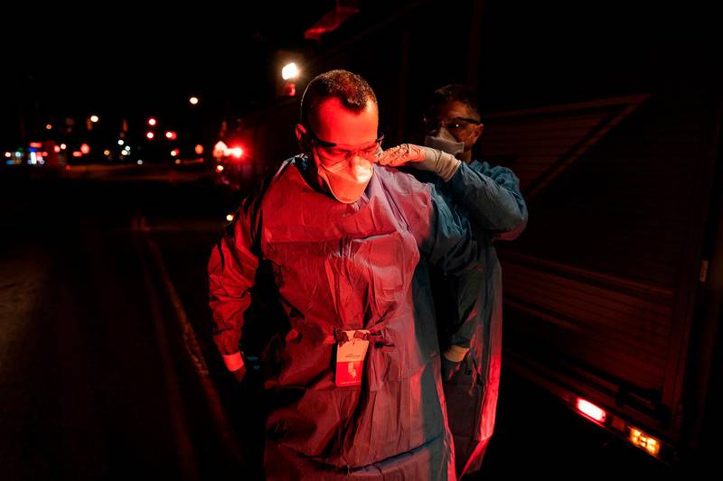 Firefighters with Anne Arundel County Fire Department put on enhanced PPE prior to treating a potential COVID-19 patient in Glen Burnie, Maryland.   AFP