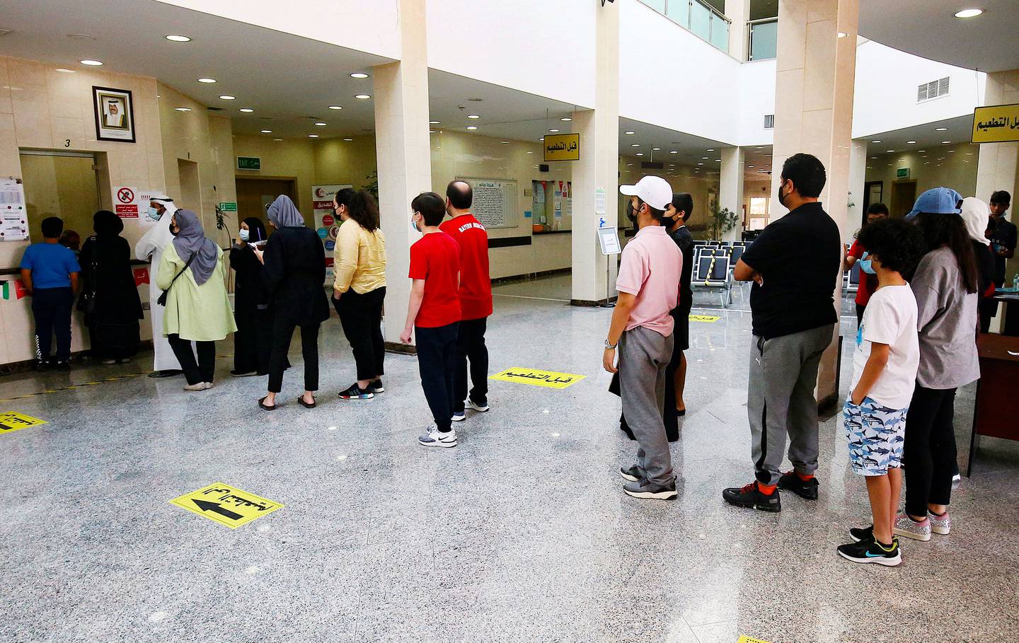 People queue to receive a dose of the Pizer-BioNTech vaccine against the coronavirus at al-Siddeeq health centre, in Kuwait City, on August 18, 2021. AFP