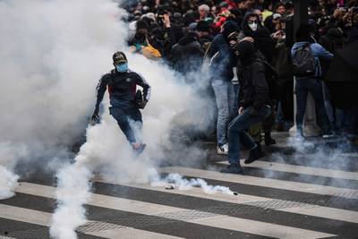 A protester kicks a tear gas canister during clashes with police. AFP