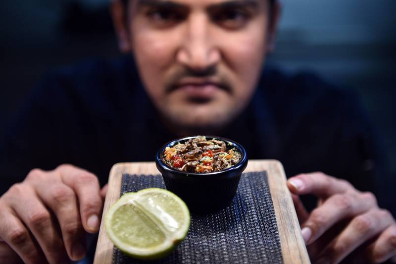 El Topo sous-chef Nowshad Alam Rasel shows off his restaurant's signature cricket dish in Sydney on March 16, 2017. Saeed Khan / AFP

