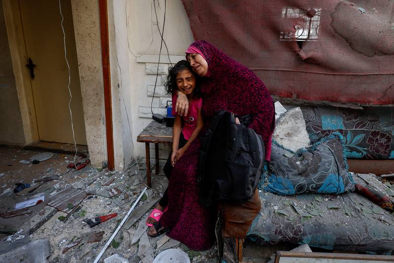 A Palestinian woman and her daughter survey the damage to their home, caused by the Israeli air strikes, in the northern Gaza Strip. Reuters