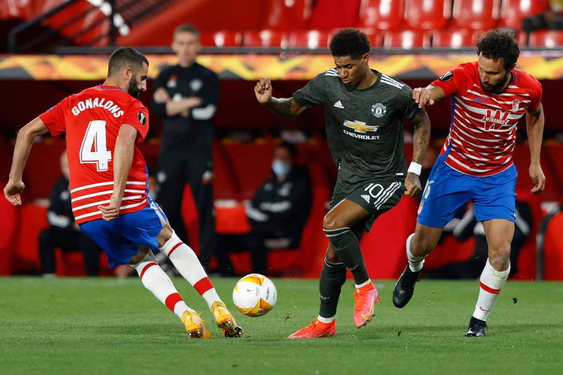 Manchester United's Marcus Rashford, center, challenges for the ball with Granada's Maxime Gonalons, left, and German during the Europa League, quarterfinal, first leg soccer match between Granada and Manchester United at the Los Carmenes stadium in Granada, Spain, Thursday, April 8, 2021. (AP Photo/Fermin Rodriguez)