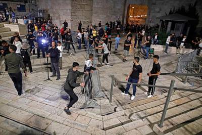 Palestinian protesters remove metallic barriers as demonstrators gather at the Damascus Gate in Jerusalem's Old City. AFP