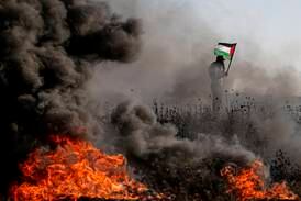 A Palestinian protester waves a flag during clashes on the eastern border of the Gaza Strip on September 22. EPA