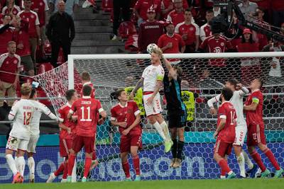 Denmark defender Simon Kjaer fights for the ball with goalkeeper Jonas Lossl. AFP