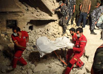 Rescuers carry the body of a victim after removing it from the rubble of a building that collapsed in Syria's northern city of Aleppo. AFP