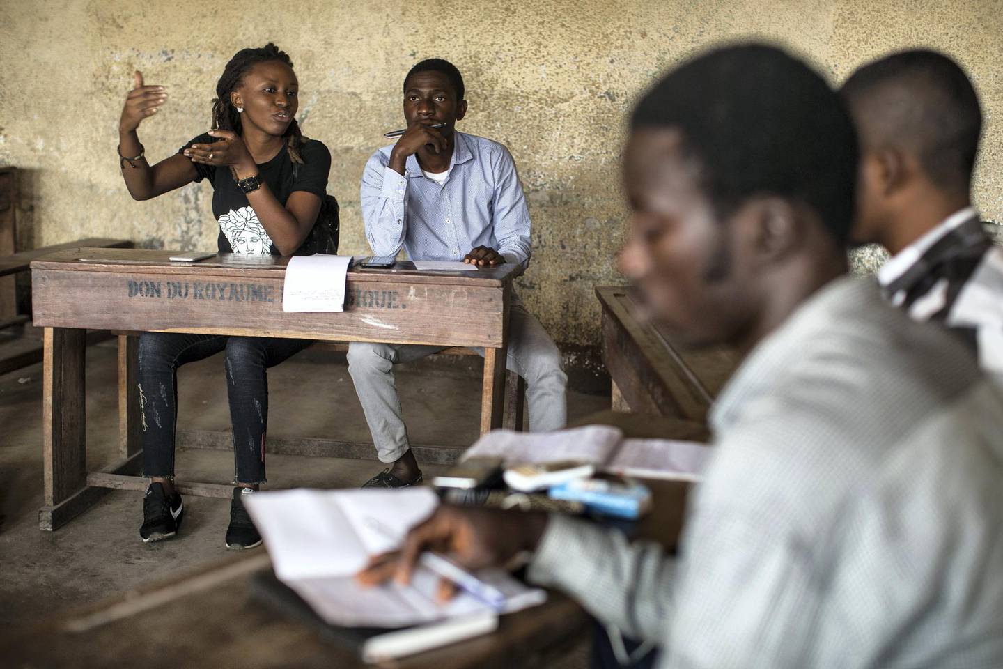 Eunice Etaka, far left, and Yves Diabikulwa, second from left, lead a "Luch-ology" class for new members in Kinshasa, DRC, Aug. 18, 2018. Etaka, a member of pro-democracy youth movement Lutte pour le Changement, or LUCHA, helps educate new members about the ideology, activities, and history of the group. 
