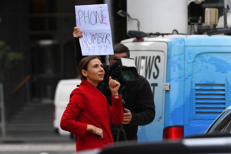 A television journalist attempts to get a phone number of someone in quarantine at Crown Promenade Hotel in Melbourne.  EPA