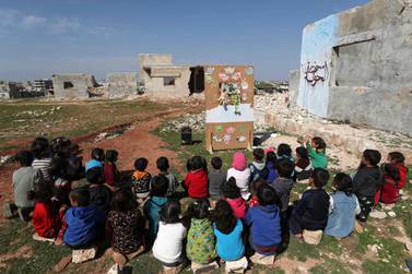 Syrian children watch a puppet show performed by a local theatre group amidst the ruins of buildings destroyed during Syria's civil war. AFP