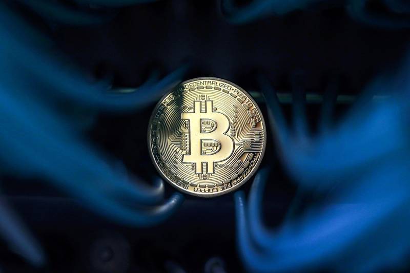 A bitcoin sits among an Ethernet cables inside a communications room at an office in this arranged photograph in London, U.K., on Tuesday, Sept. 5, 2017. Bitcoin steadied after its biggest drop since June as investors and speculators reappraised the outlook for initial coin offerings. Photographer: Chris Ratcliffe/Bloomberg