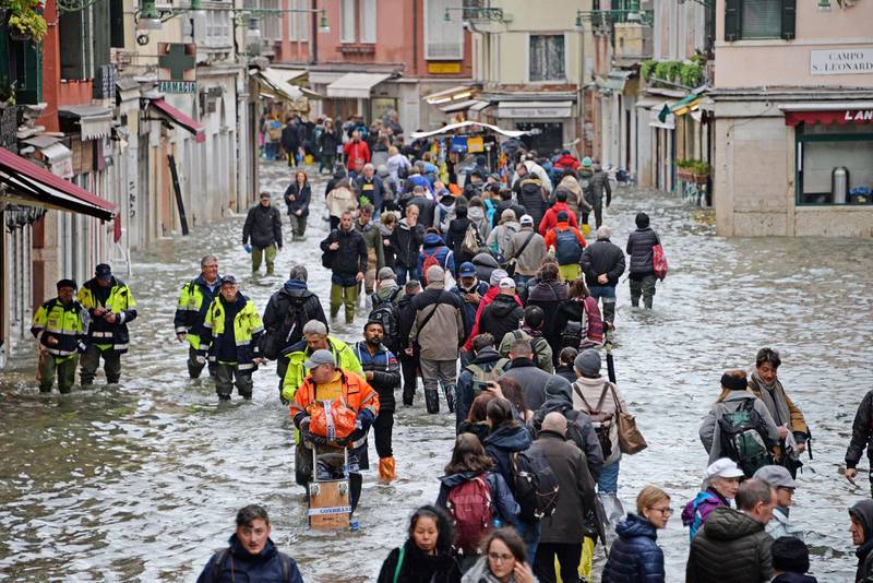 epa07999377 People wade through high water in Venice, northern Italy, 15 November 2019. Venice closed St Mark's Square due to fresh flooding in the city. The city is currently suffering its second-worst floods on record, with the high-water mark reaching 187cm on Tuesday. The water level had dropped down significantly but it is forecast to go back up to 160cm today.  EPA/ANDREA MEROLA