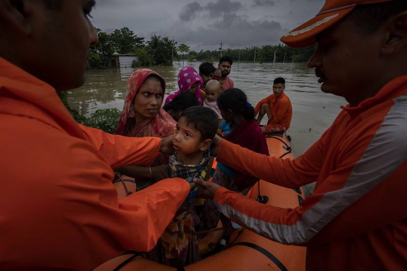 Rescuers evacuate villagers from the flooded Korora village, west of Guwahati, in India's Assam state. AP 
