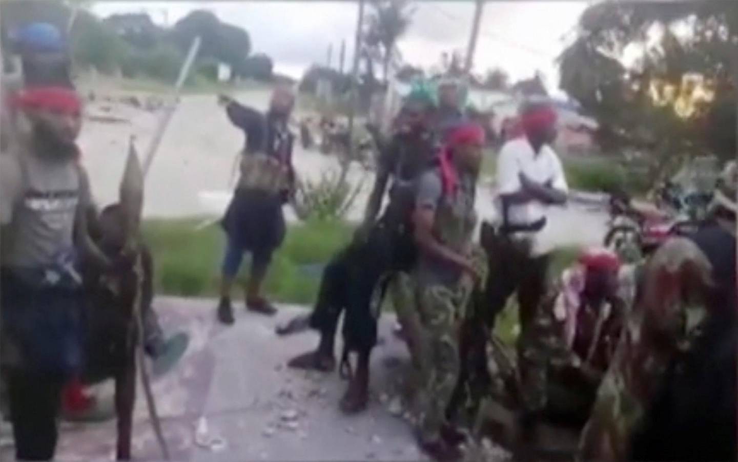 In this image taken from militant video released by the Islamic State group on Monday March 29, 2021, purporting to show fighters near the strategic north eastern Mozambique town of Palma, as the militant group claimed it had taken control of the area after five days of conflict.  The video from the Islamic State group claims to show fighters in or near Palma, but cannot be independently verified by The Associated Press. (AMAQ Militant video via AP)