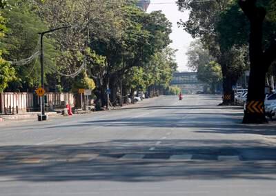 A woman crosses an empty street in downtown Yangon. For the silent strike, members of the public stayed at home and businesses closed from 10am to 4pm. EPA
