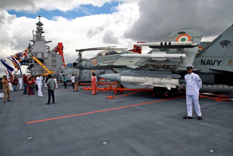 Family members of Indian Navy officials have their photographs taken next to parked fighter jets and helicopters on the deck of the ship. Reuters