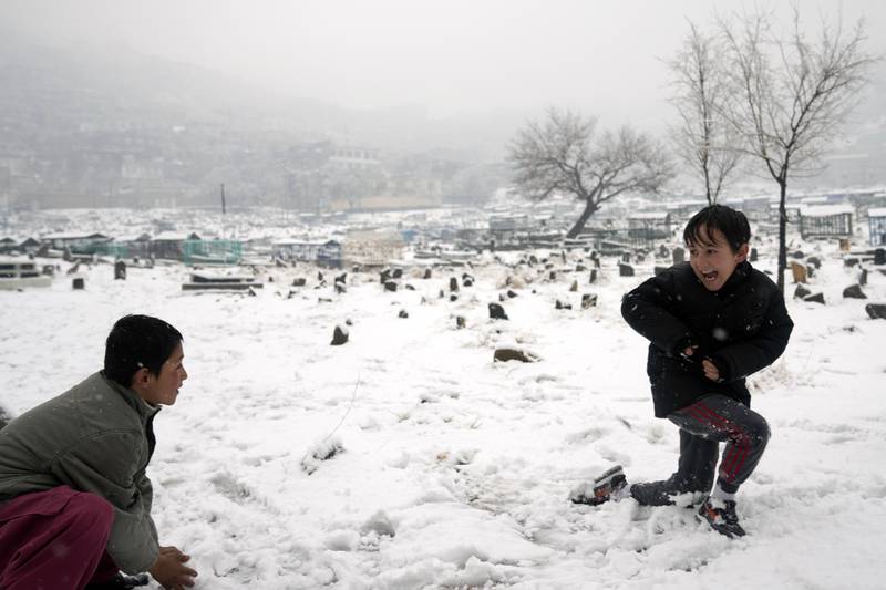 Boys play with snow in a cemetery in Kabul. AP