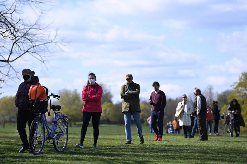 People stand in a socially distanced as they queue at the testing centre in Brockwell Park. AFP