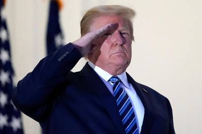 President Donald Trump salutes Marine One as he stands on the balcony outside of the Blue Room as returns to the White House. AP Photo
