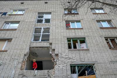 A woman looks out from a building damaged by Russian shelling in Mykolaiv, 100 kilometres away from Odesa, western Ukraine. AFP