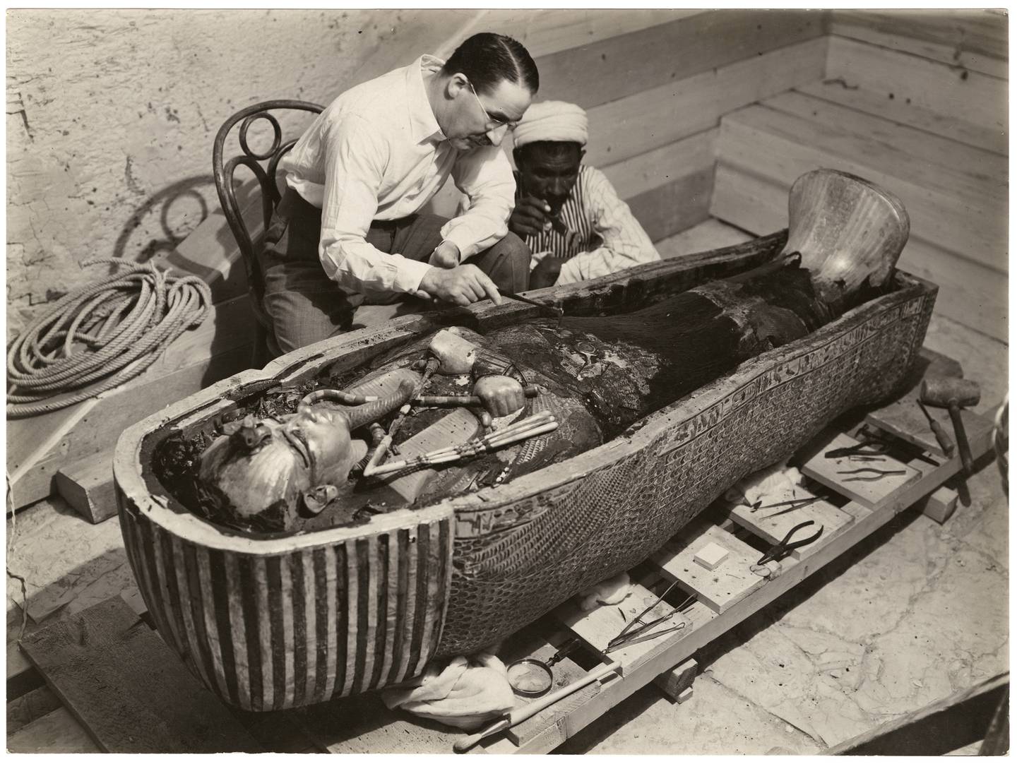 British archaeologist Howard Carter and an Egyptian worker examining the inner coffin of ancient Egyptian King Tutankhamun. Photo: The Bodleian Libraries, University of Oxford