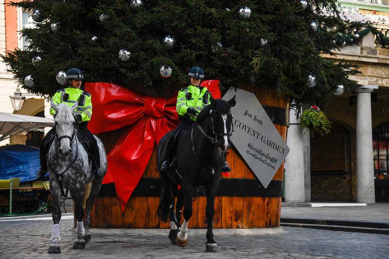 Two police officers ride their horses backdropped by a Christmas tree in Covent Garden, in London. AP Photo