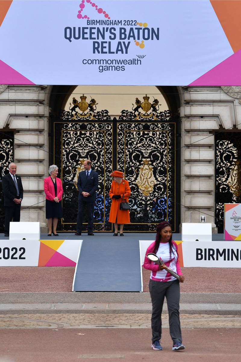 Kadeena Cox, the first baton-bearer commences the baton's journey back in October 2021, as Queen Elizabeth watches on. AFP