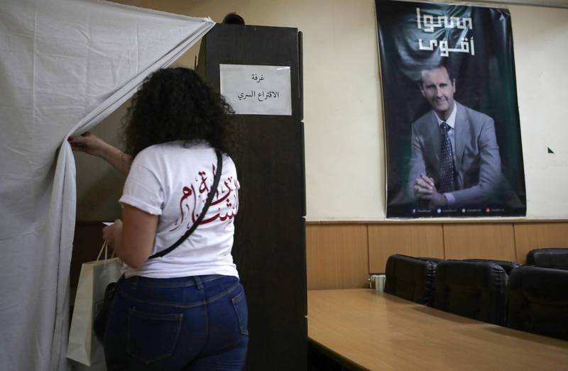 A  woman prepares to vote at a polling station in the Syrian capital Damascus. AFP
