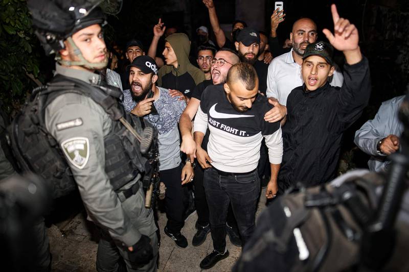 Palestinian protesters chant slogans before Israeli border guards on May 6, 2021. They were demonstrating in solidarity with local residents of the Sheikh Jarrah district of Israeli-annexed East Jerusalem who face eviction. AFP