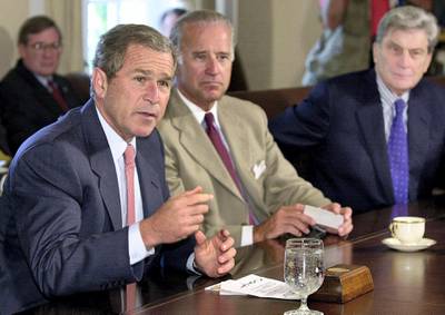 US President George W. Bush (L) answers reporter's questions prior to a bipartisan meeting with congressional leaders in the Cabinet Room of the White House, 25 July 2001.  Listening are Senator Joe Biden (C) D-DE and Senator John Warner (R-VA).      AFP PHOTO/Mike THEILER (Photo by MIKE THEILER / AFP)