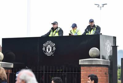 Police watch over fans outside Old Trafford. EPA
