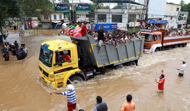 Passengers travel in a truck to a safer place in Ernakulam district. AFP