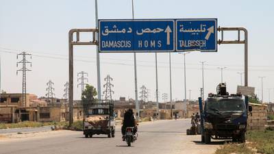 A picture taken on August 3, 2017 shows vehicles driving past a roadsign that says "Talbiseh" in the eponymous central Syrian rebel-held town, north of Homs, along the highway between the capital Damascus and the central city of Homs.
A ceasefire between government forces and rebels went into effect in part of central Syria on August 3, 2017 after Russia struck a deal with the opposition on a safe zone in the northern parts of Homs province. 
The truce is the third to be established in Syria, which has been ravaged by six years of civil war that have left more than 300,000 people dead. / AFP PHOTO / MAHMOUD TAHA