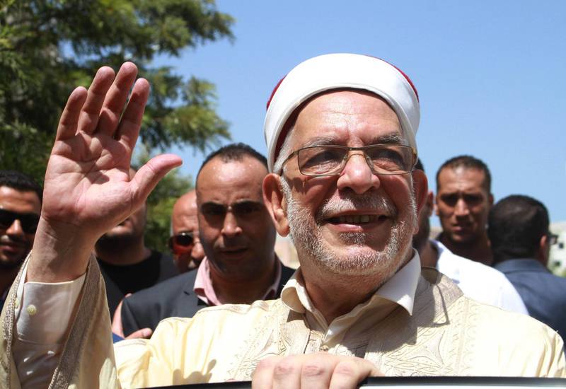 Abdelfattah Mourou (C), Tunisia's interim parliamentary speaker and Islamist-inspired Ennahda Party politician, waves to supporters and journalists after submitting his candidacy for the upcoming early presidential elections at the Independent High Authority for Elections (ISIE), in the capital Tunis on August 9, 2019. Ennahdha Party had announced that Mourou would be their presidential candidate for the first time on August 7, ahead of polls next month. Mourou, 71, was appointed interim parliamentary speaker following the death last month of president Beji Caid Essebsi. The Ennahdha politician had previously served as the deputy speaker, and changed roles after the then parliamentary head Mohamed Ennaceur stepped up as interim president. / AFP / HASNA
