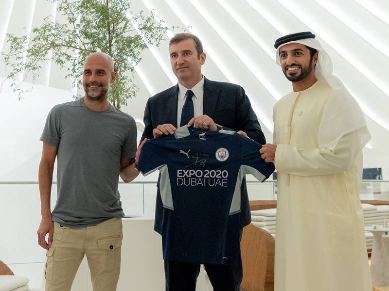 Left to right: Manchester City manager Pep Guardiola, left, chief executive Ferran Soriano, are presented with an Expo 2020 Dubai shirt by Sheikh Rashid bin Humaid Al Nuaimi, president of the UAE Football Association. Photo: UAE FA