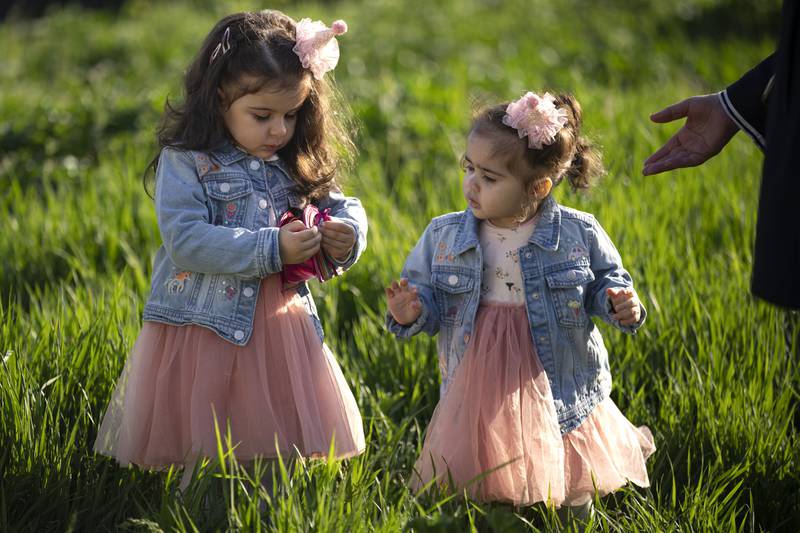 Little girls walk in the grass after attending Eid Al Fitr prayers in Bucharest, Romania.  AP