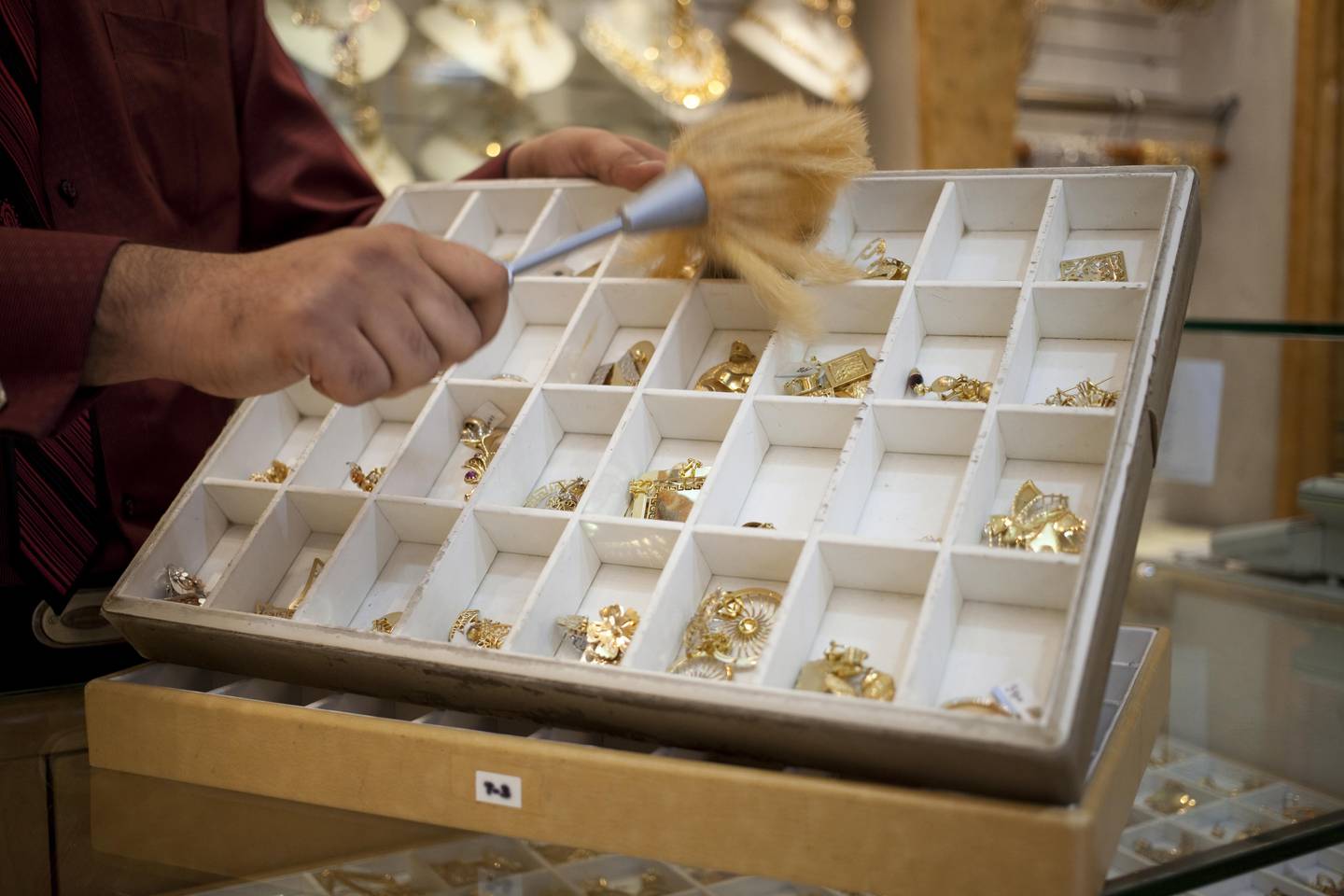 Dubai, United Arab Emirates - January 07, 2013 - Kartik Satikunver, a vendor from Gujurat dusts off gold jewelry at Kanz Jewels in Deira Gold Souk.  (Razan Alzayani / The National)  