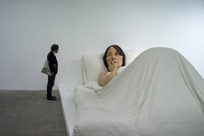 A visitor looks at the sculpture 'In bed' by Australian artist Ron Mueck on display during the exhibition Vivid Memories at the Fondation Cartier Museum in Paris, France, May 9, 2014. The exhibition celebrates the 30th anniversary of the Cartier Foundation by focusing on the works the museum has collected since 1984. The exhibition runs from May 10 to September 21 2014.  EPA