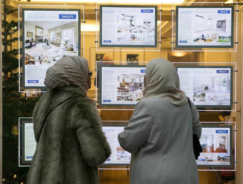 Window shopping at an estate agency in South Kensington, London. Analysts say prices are on a downturn but do not agree on what that may mean for the long-term health of the housing market. PA