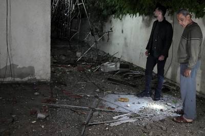 Palestinians inspect damage to their home. AP