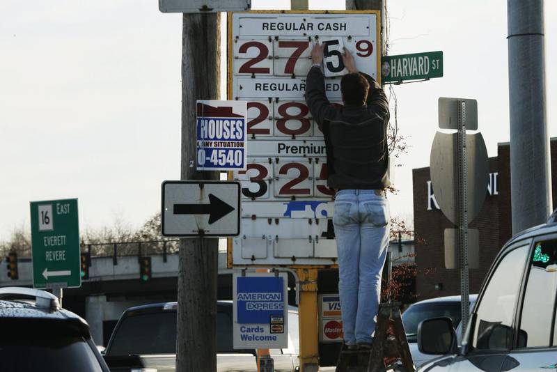 A man changes the price for a gallon of gasoline at a gas station in Medford, Massachusetts, on December 4. Brent crude oil fell below US$69 a barrel on Thursday after Saudi Arabia announced deep cuts in selling prices for Asian and US buyers, a week after refusing to support OPEC output cuts. Brian Snyder / Reuters