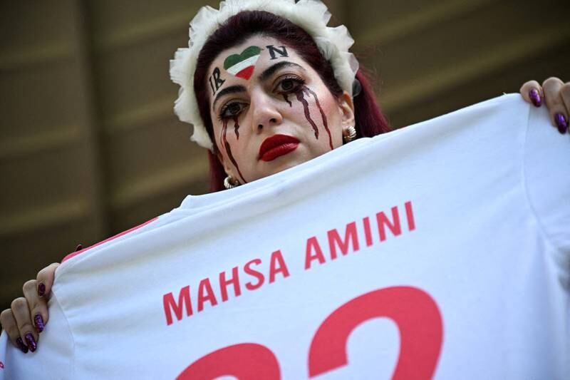An Iranian fan holds a jersey in memory of Mahsa Amini before the November 25 World Cup match against Wales. Reuters