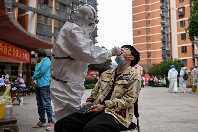 A medical worker takes a swab sample from a man in a neighborhood in Wuhan, in China’s central Hubei province.  AFP